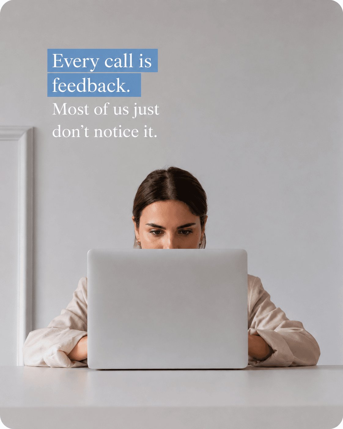 A person working at a laptop, with the words “Every call is feedback. Most of us just don’t notice it.” on the wall behind them.